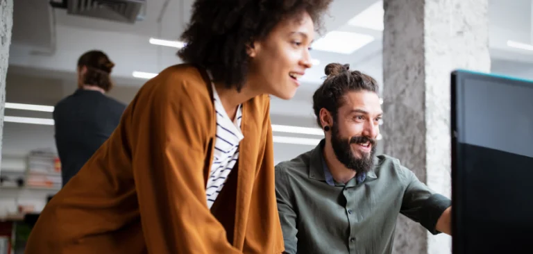 Kolleg:innen im Büro vor einer Computer