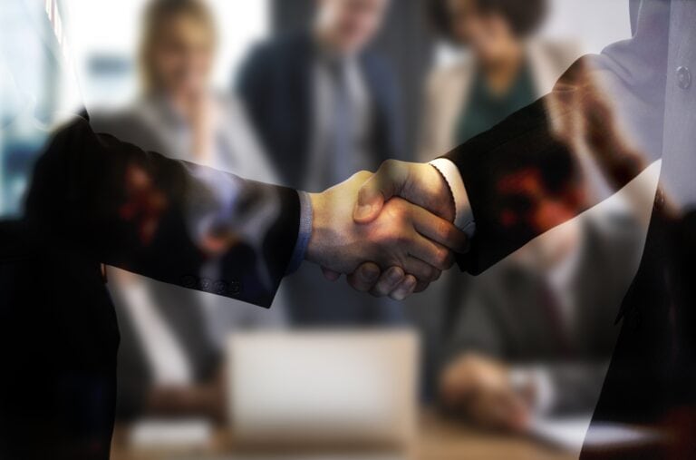 Geschäftlicher Handschlag vor unscharfem Hintergrund mit digitaler Netzwerk-Überlagerung